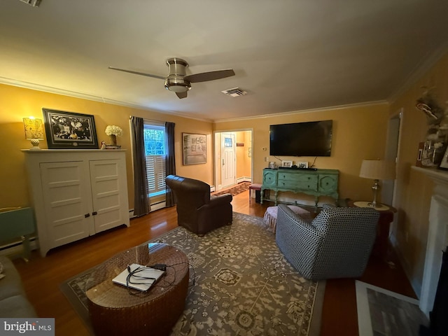 living room featuring wood finished floors, visible vents, ceiling fan, ornamental molding, and baseboard heating