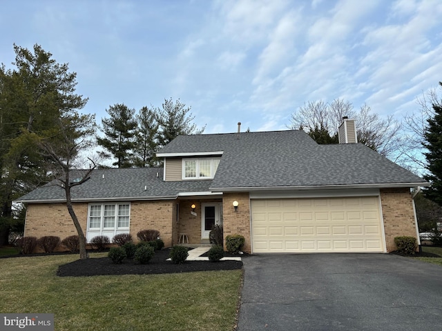 traditional-style home featuring brick siding, a shingled roof, a front lawn, aphalt driveway, and a chimney