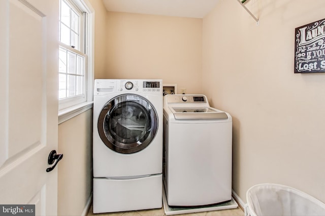 clothes washing area featuring separate washer and dryer and laundry area