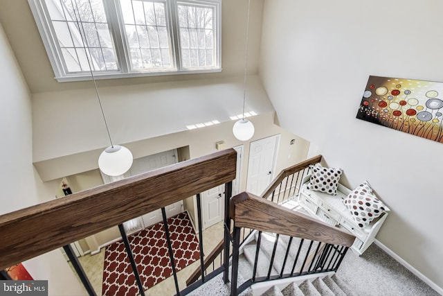 stairs with a high ceiling, plenty of natural light, carpet, and baseboards