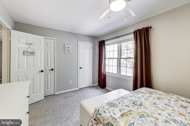 carpeted bedroom with baseboards, two closets, and ceiling fan