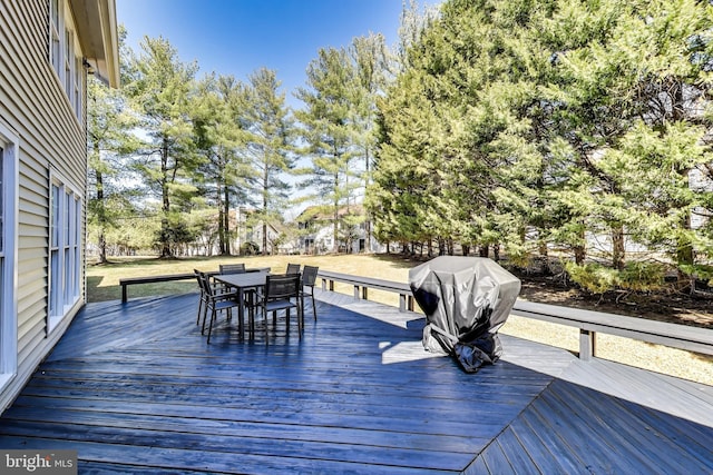 wooden terrace featuring grilling area and outdoor dining space