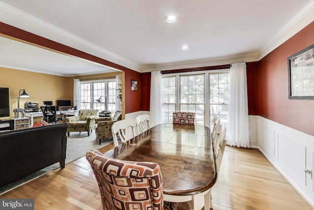 dining room featuring recessed lighting, a wainscoted wall, light wood-style flooring, and crown molding