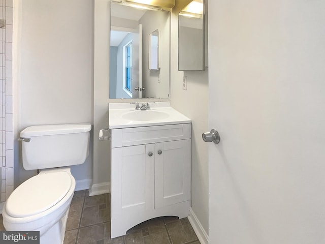 bathroom with tile patterned floors, baseboards, toilet, and vanity