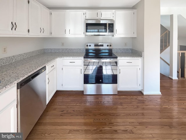 kitchen featuring dark wood finished floors, light stone countertops, white cabinetry, and stainless steel appliances