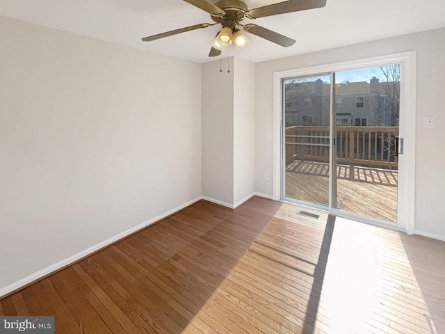 spare room featuring hardwood / wood-style flooring, baseboards, and visible vents