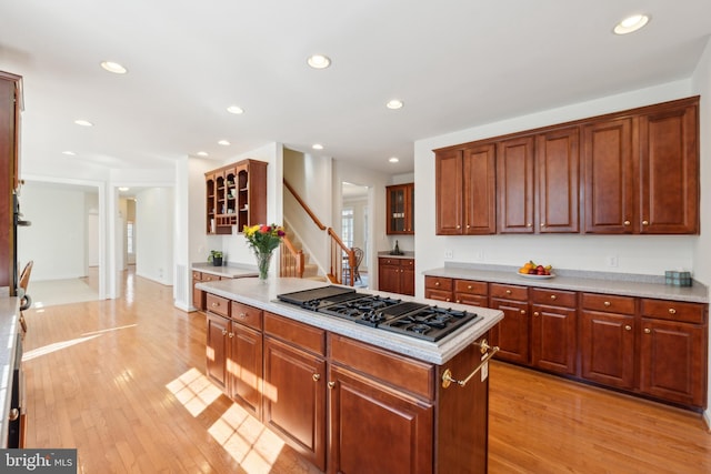 kitchen with light countertops, recessed lighting, light wood-type flooring, and stovetop with downdraft