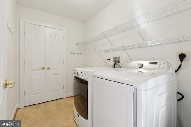 washroom with washer and dryer, baseboards, and laundry area