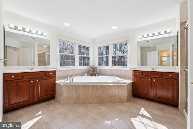 bathroom with a sink, two vanities, a bath, and a shower stall