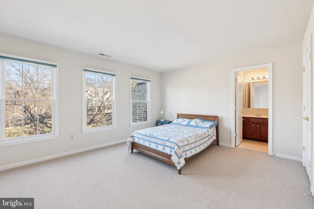 bedroom featuring visible vents, connected bathroom, baseboards, light colored carpet, and a sink