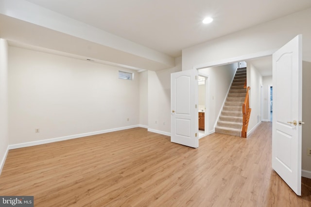 finished basement with recessed lighting, light wood-style flooring, stairs, and baseboards