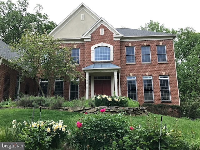 colonial inspired home with brick siding