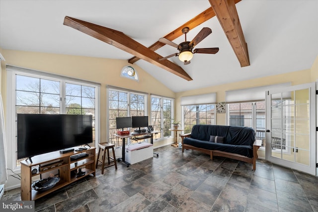 living room featuring stone finish floor, vaulted ceiling with beams, baseboards, and a ceiling fan