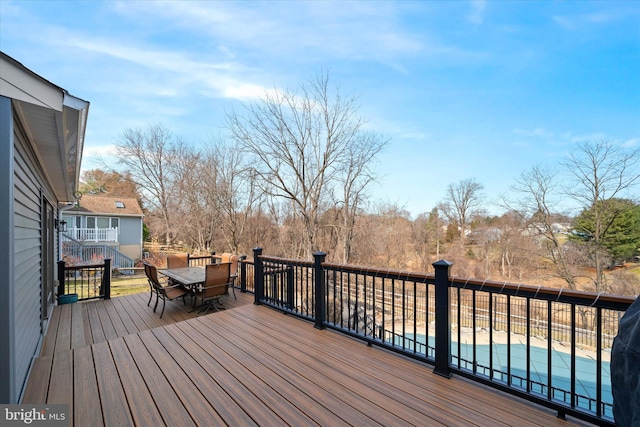 deck featuring outdoor dining area and a fenced in pool