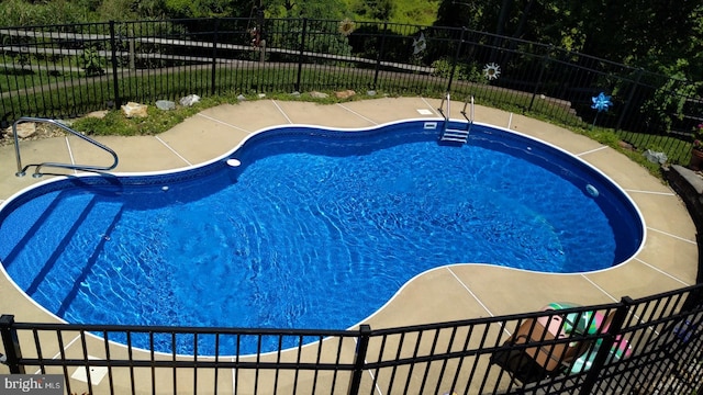 view of pool with a patio area, a fenced in pool, and fence