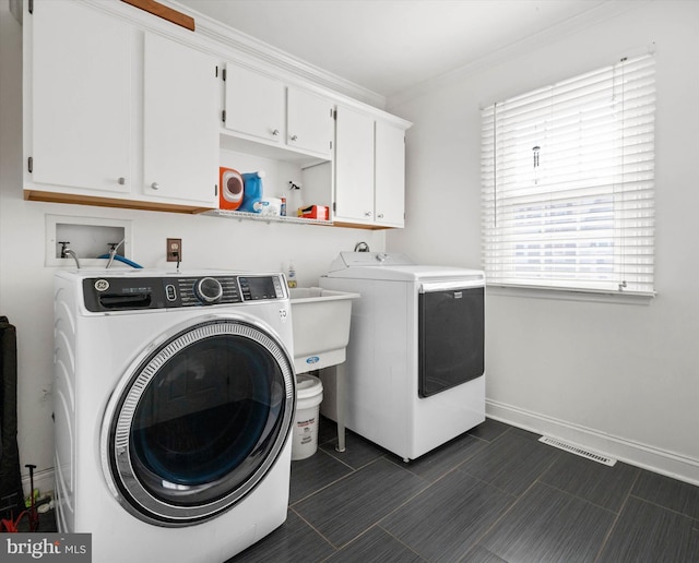 washroom with baseboards, visible vents, washing machine and clothes dryer, cabinet space, and crown molding