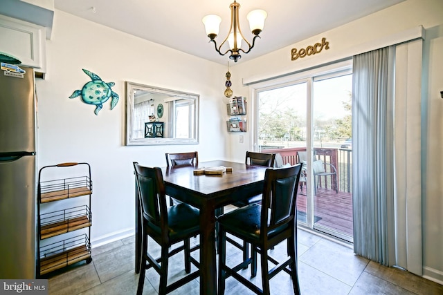 dining room featuring tile patterned floors, baseboards, and an inviting chandelier