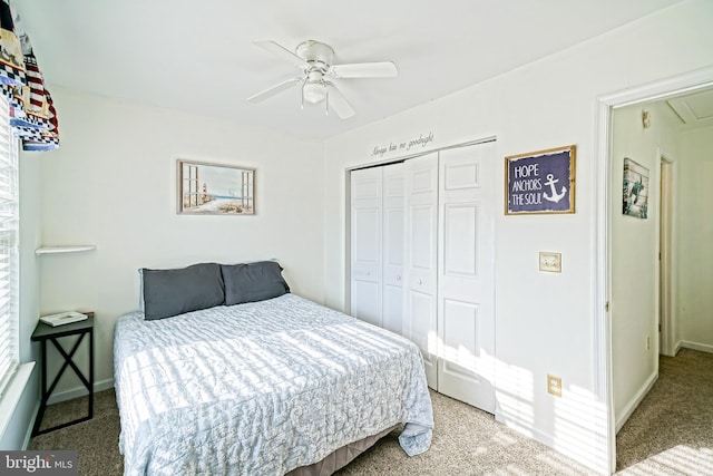 carpeted bedroom with a closet, baseboards, and ceiling fan