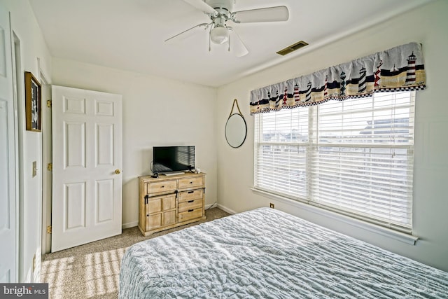 carpeted bedroom with visible vents, ceiling fan, and baseboards