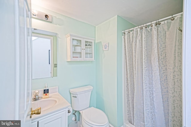 bathroom with vanity, curtained shower, and toilet