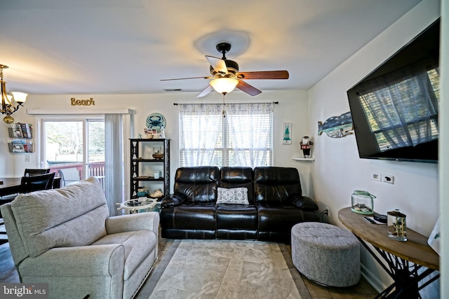 living area with visible vents and ceiling fan with notable chandelier