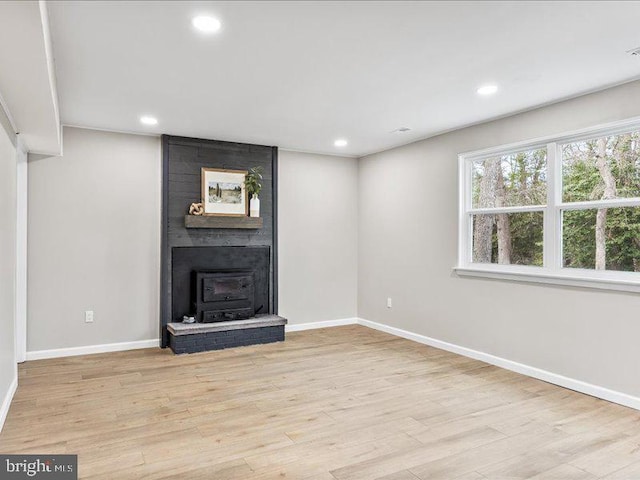 unfurnished living room with light wood finished floors, recessed lighting, and baseboards