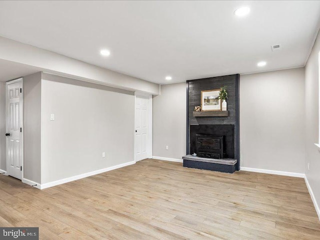 unfurnished living room with visible vents, baseboards, light wood-style flooring, a fireplace, and recessed lighting