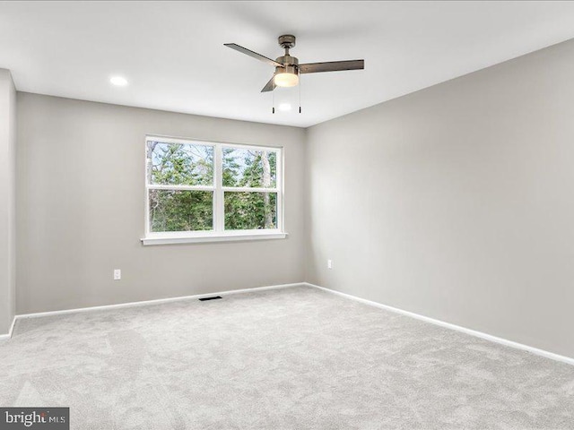 carpeted empty room featuring visible vents, baseboards, and a ceiling fan