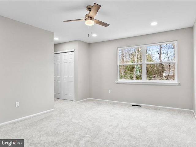 carpeted spare room featuring visible vents, recessed lighting, baseboards, and ceiling fan