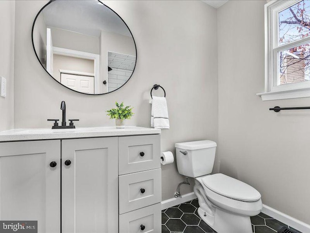 bathroom featuring tile patterned flooring, toilet, vanity, and baseboards