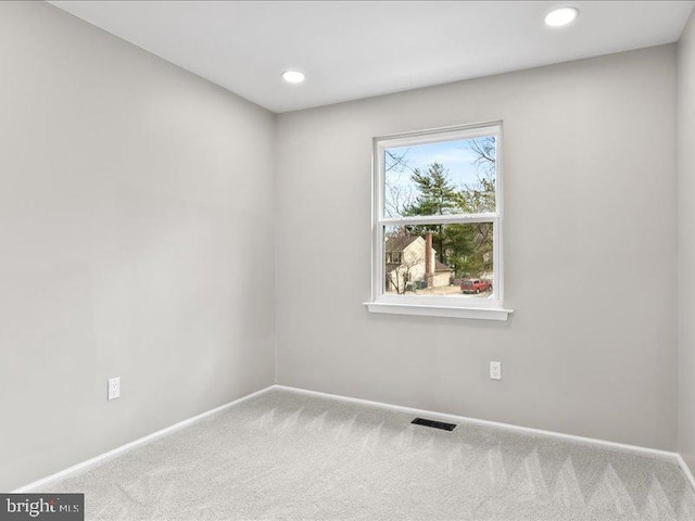 carpeted empty room featuring recessed lighting, visible vents, and baseboards