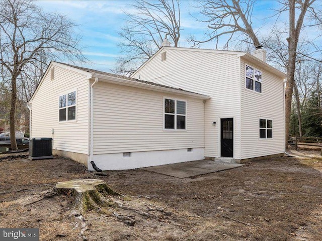 back of property with crawl space, central AC unit, a chimney, and a patio