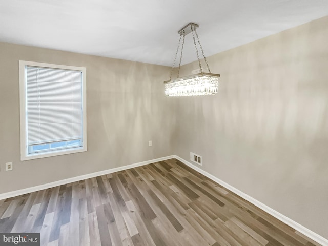 unfurnished dining area featuring wood finished floors, visible vents, and baseboards