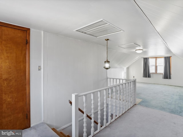 corridor with carpet, vaulted ceiling, and an upstairs landing