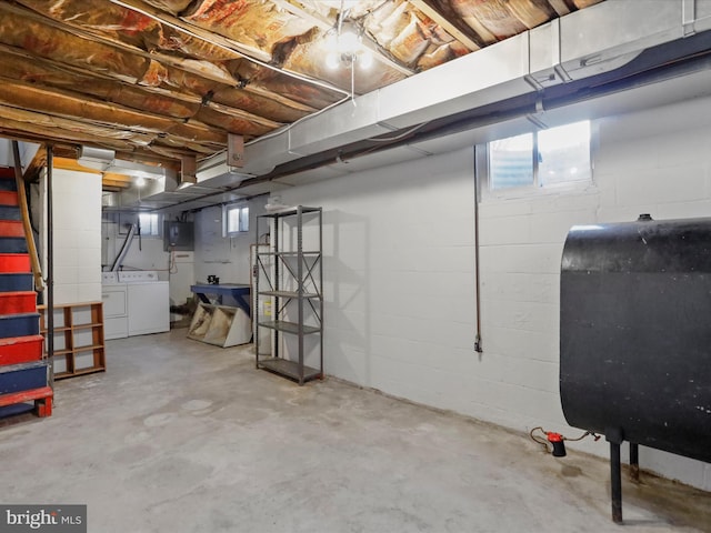 basement featuring electric panel, heating fuel, and washer and clothes dryer