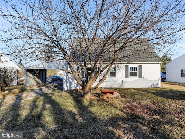 exterior space with a yard, roof with shingles, and an outdoor structure