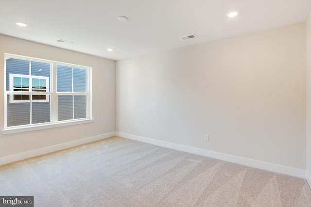 carpeted spare room with visible vents, recessed lighting, and baseboards