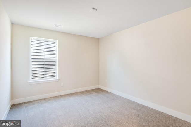 carpeted empty room with visible vents and baseboards