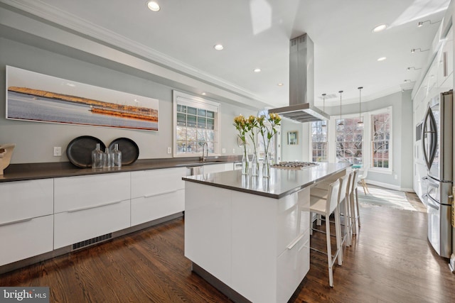 kitchen with dark countertops, modern cabinets, white cabinets, and island range hood