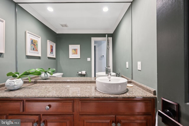 bathroom with vanity, crown molding, toilet, and visible vents