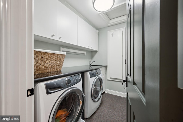 clothes washing area with baseboards, cabinet space, independent washer and dryer, and a sink