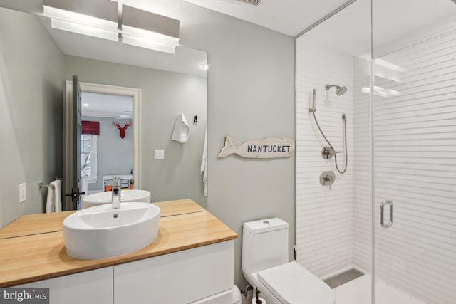 bathroom featuring toilet, a stall shower, and vanity