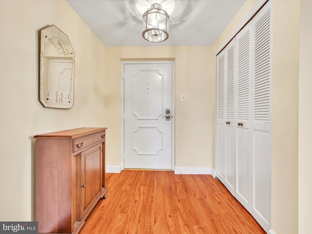 foyer entrance with baseboards and light wood-style flooring