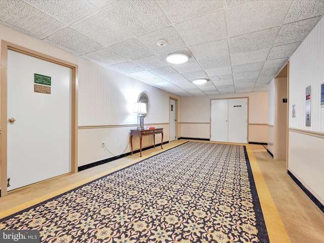 interior space with light carpet and a paneled ceiling