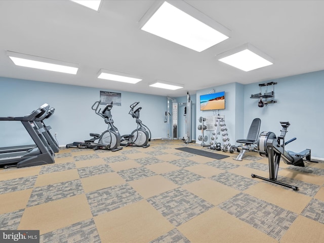 exercise room with baseboards and carpet flooring