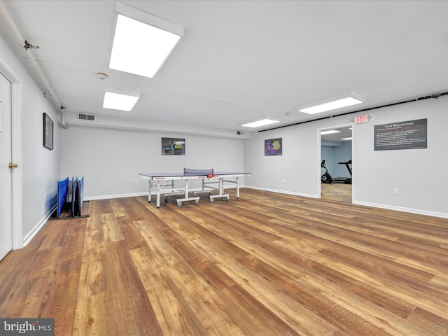 recreation room featuring visible vents, baseboards, and wood finished floors