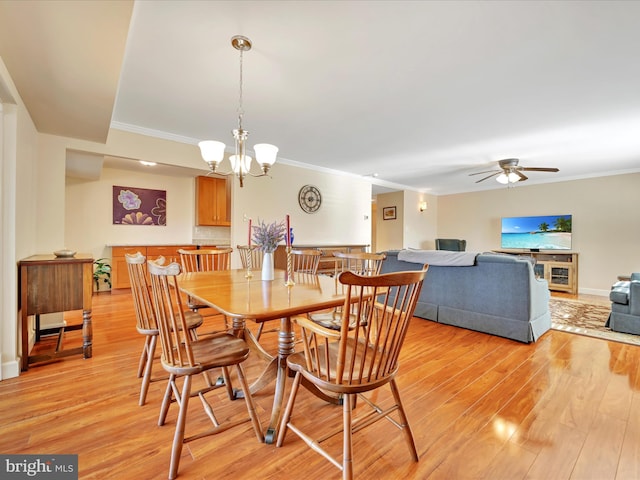 dining space with ceiling fan with notable chandelier, light wood-type flooring, baseboards, and ornamental molding