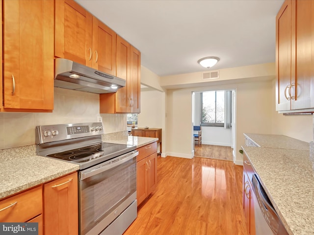 kitchen with baseboards, visible vents, under cabinet range hood, appliances with stainless steel finishes, and light wood-type flooring