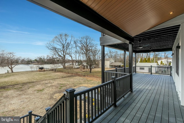 wooden deck with a lawn and a water view