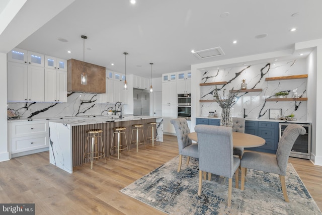 dining room with attic access, recessed lighting, beverage cooler, and light wood-type flooring